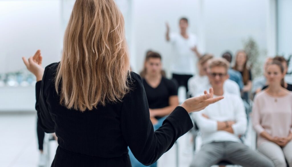 Femme dans une attitude professionnelle parlant devant un groupe