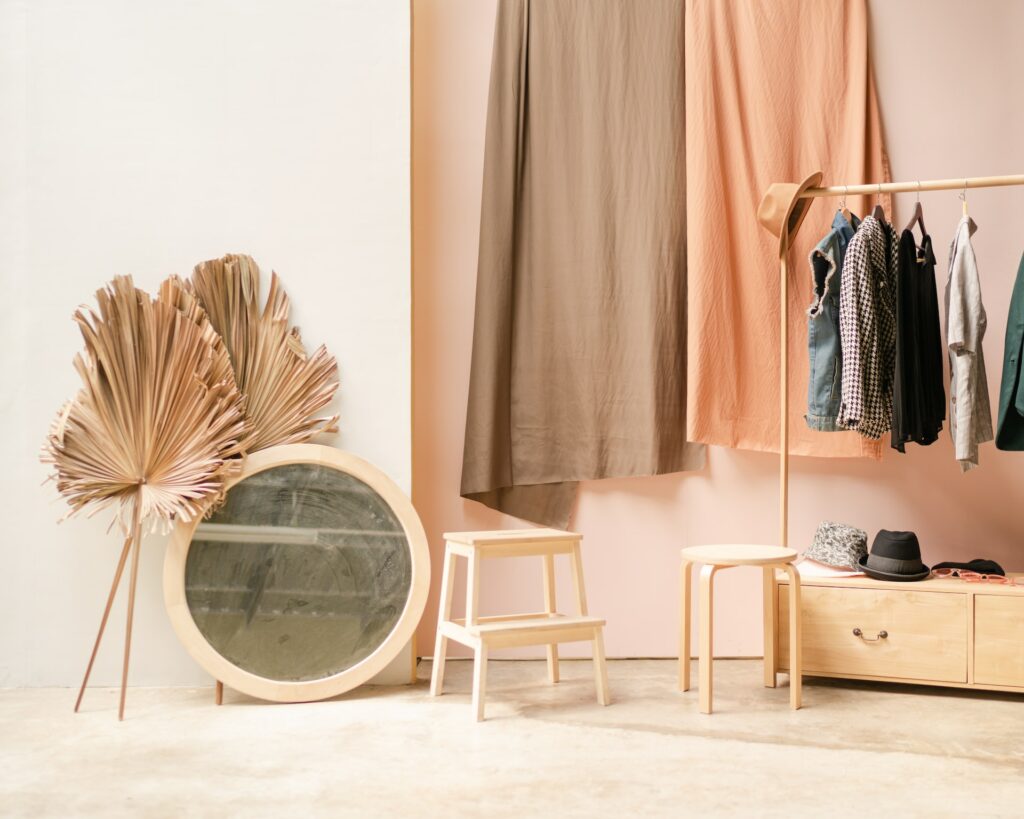 SB Image de Soi, penderie dans des tons pêche avec des rideaux au fond, un miroir et du mobilier en bois